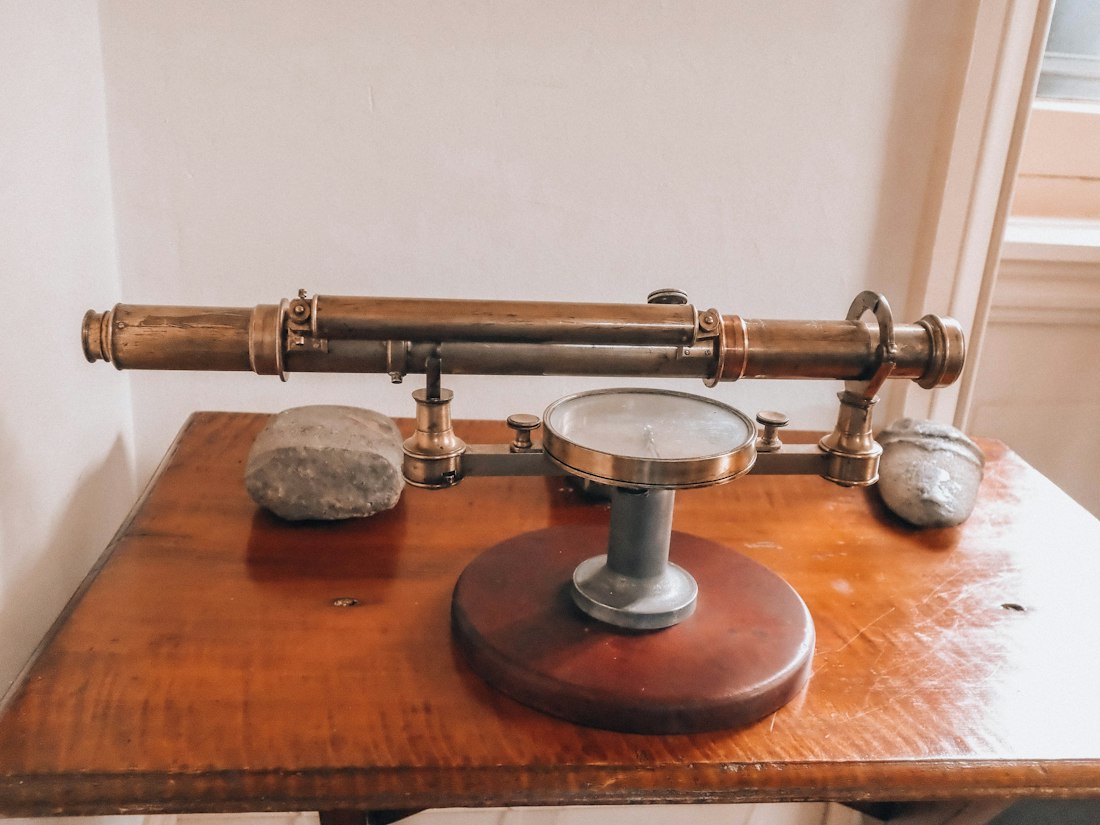 An antique brass instrument on a wooden desk
